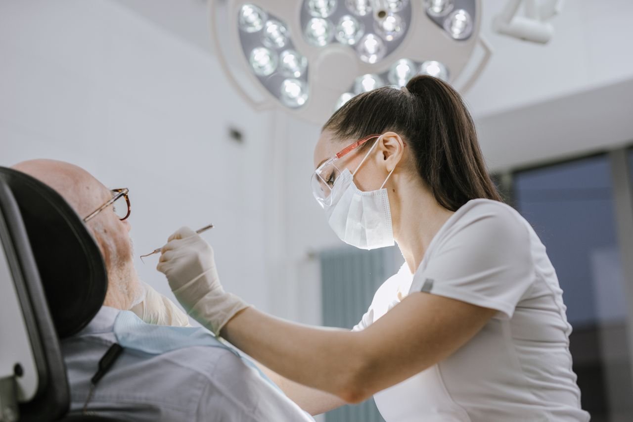 Home Female dentist working on a patient in a modern dental office with bright lighting.