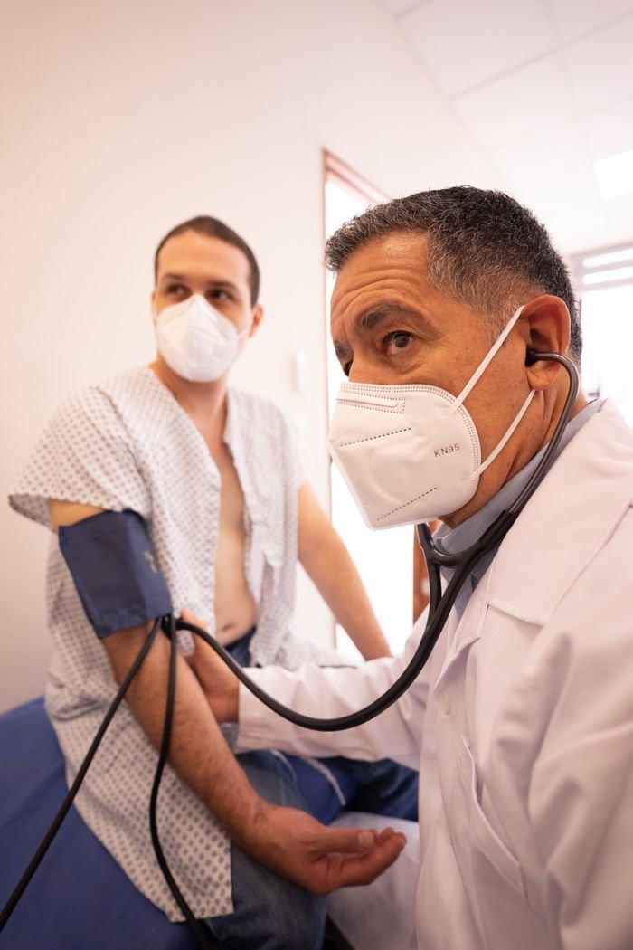 Home Healthcare professional measuring a patient's blood pressure during a clinical consultation.